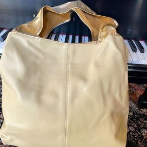 Large leather bag with gold straps.